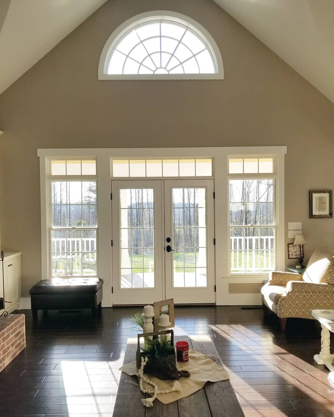 traditional living room with white french doors surrounded by white windows on either side