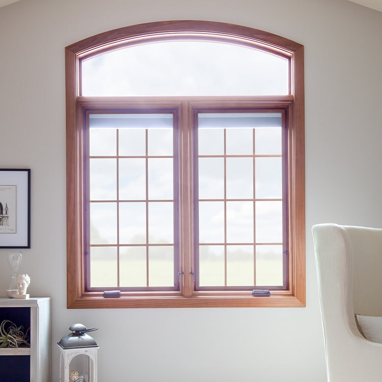 two wood casement windows with an arched wood transom overhead.