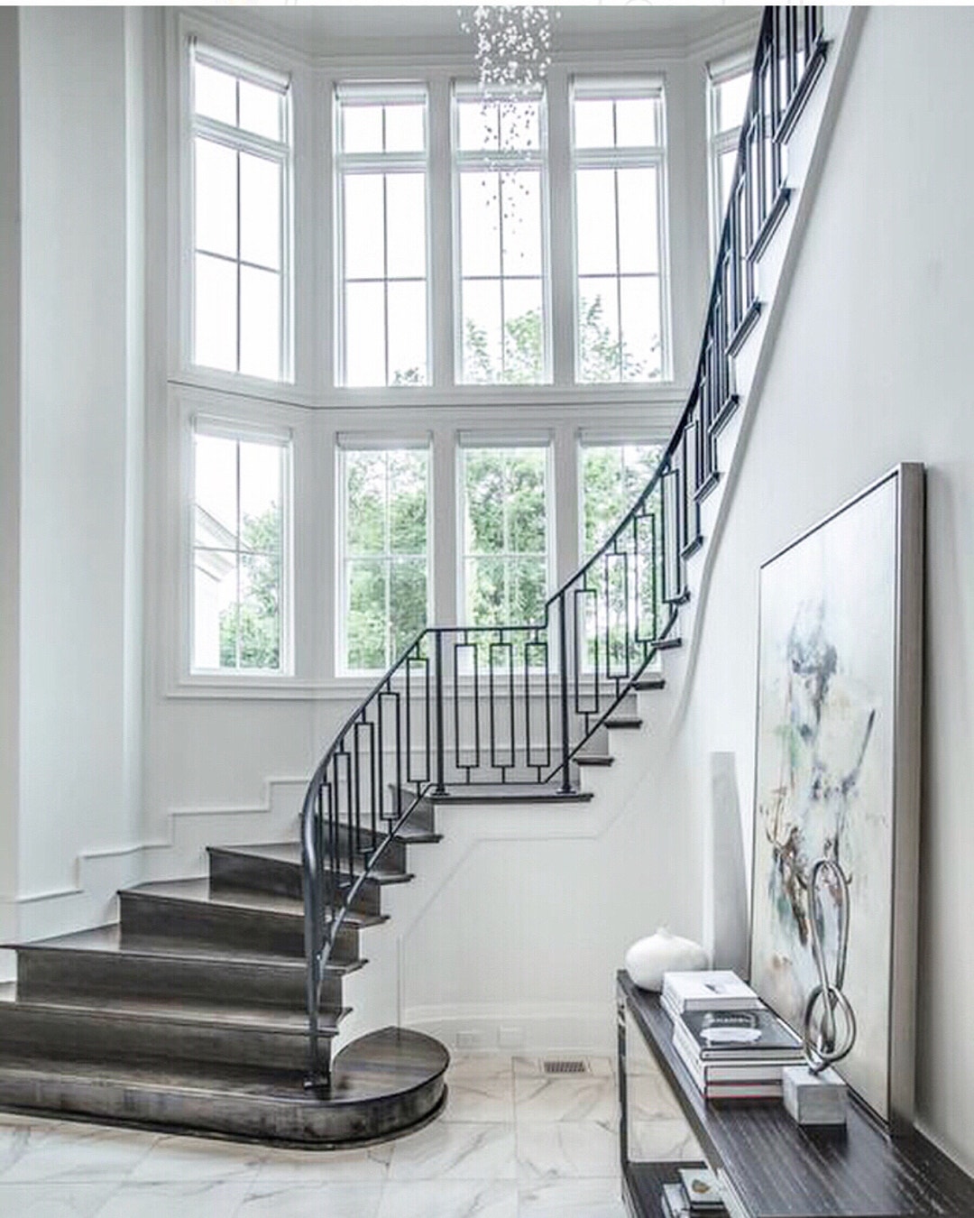 curved wall full of white windows with a grand carpeted staircase
