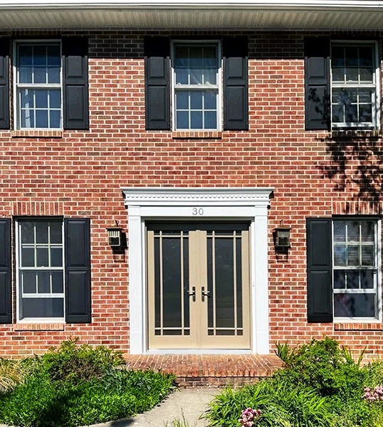 Frontside view of Mechanicsburg home with newly installed tan front door elevating colonial-style home entryway.