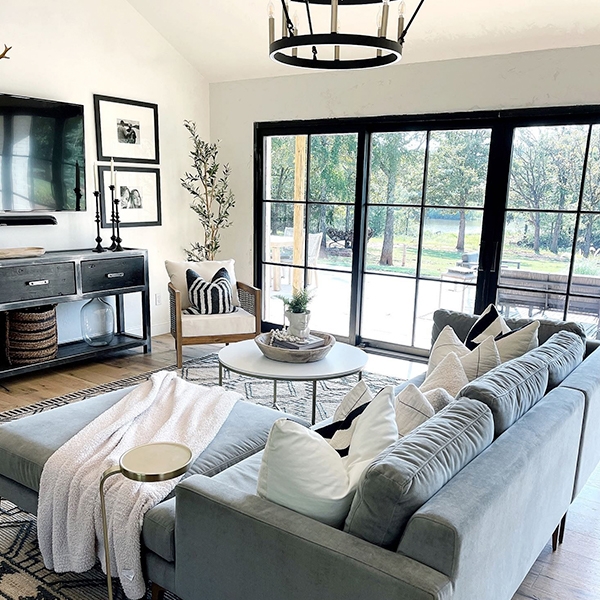 Black-trimmed sliding doors frame this contemporary living room that leads to a stone patio