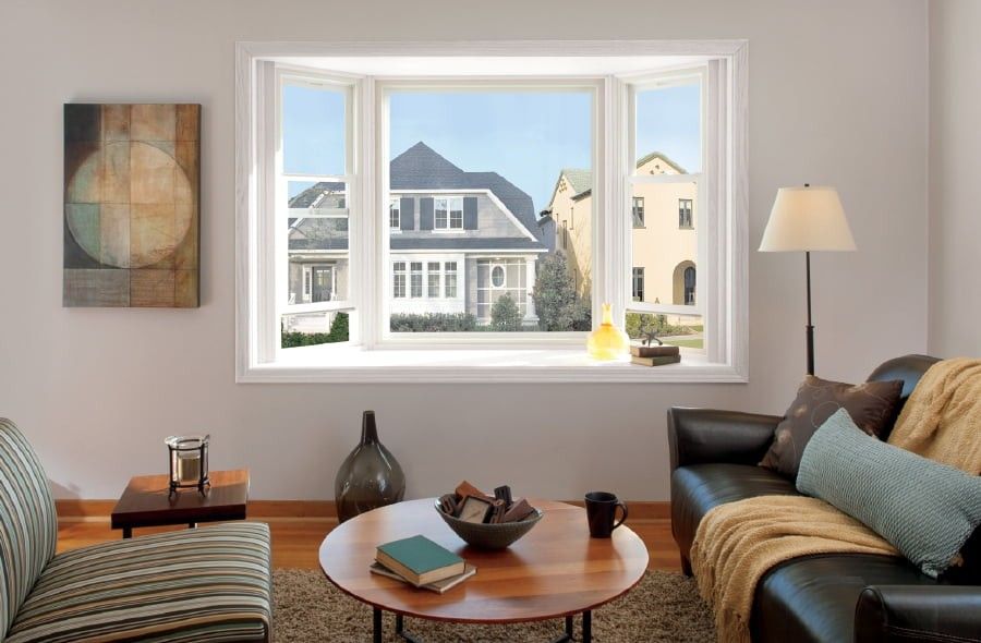 White bay windows in a contemporary living room with a view of neighbors' homes