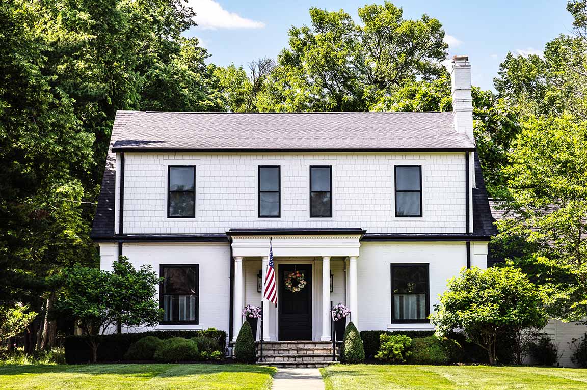 Columbus Worthington home with white brick, black trim, and symmetrical windows.