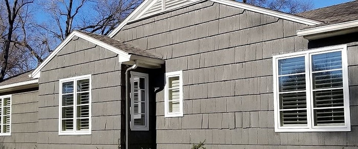 three sets of casement windows along the side of a wood-sided home in Kansas