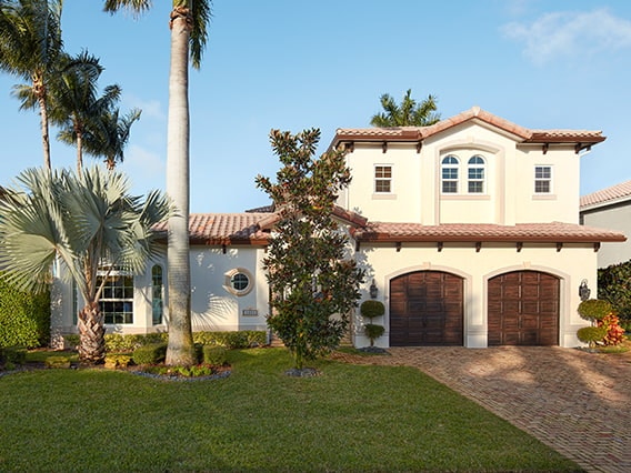 Tall palm trees aside a Spanish-style home exterior