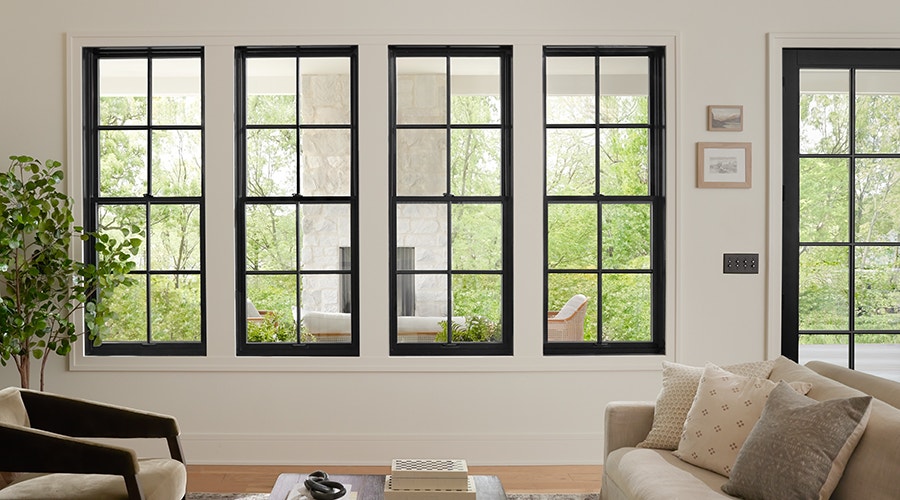 four black double-hung windows in a row on a tan kitchen wall.