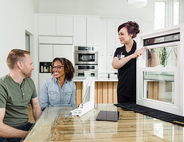 a man and a woman are enjoying the in-home consultation by a Pella representative