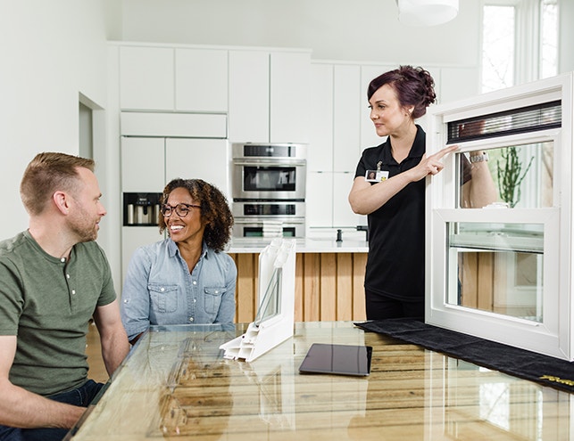 a man and a woman are enjoying the in-home consultation by a Pella representative