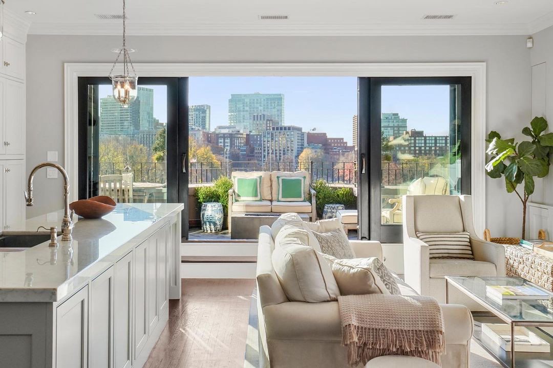 Black sliding French doors part in the middle, blending an indoor living room with an outdoor balcony.
