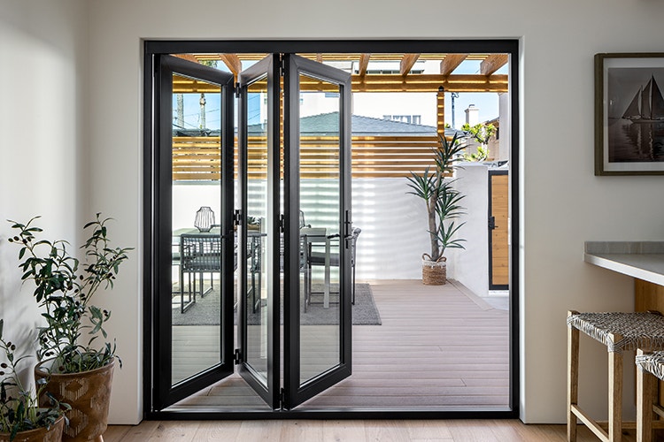 a five-panel bifold patio door in natural wood finish with 1 panel on the left and 4 on the right