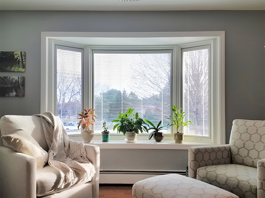 a traditional living room featuring a white-trimmed bay window unit