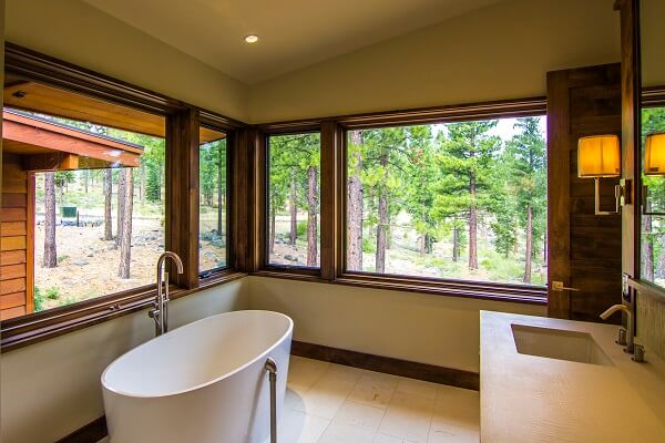 Wood stained casement and fixed windows gives bathroom a panoramic view