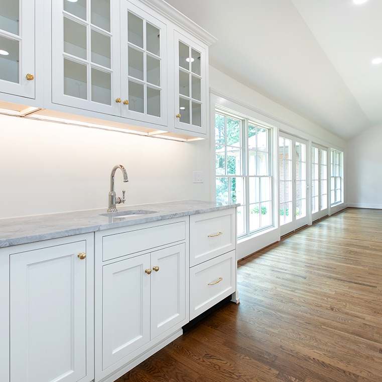 White windows and doors with traditional grille pattern matches white kitchen cabinetry. 