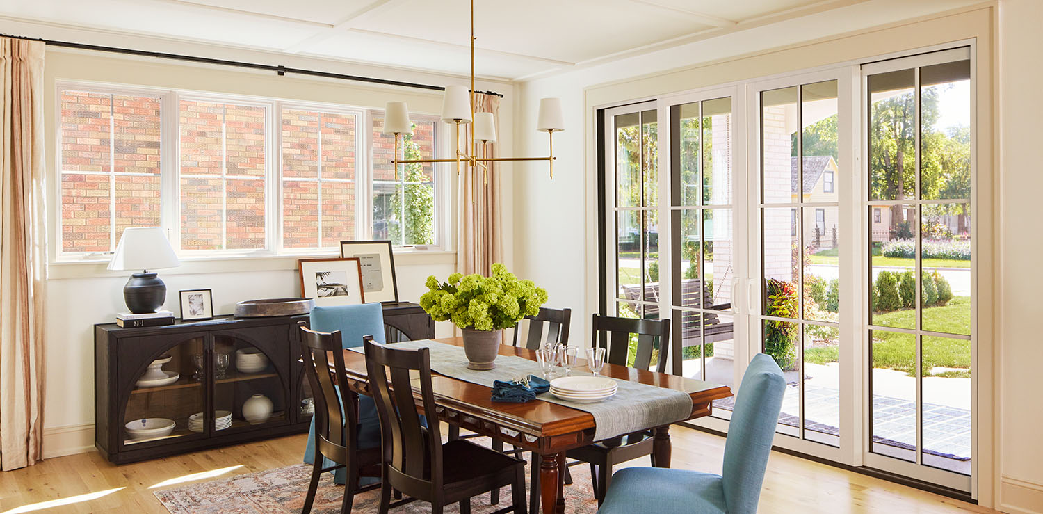 Columbus dining room with large windows and a wooden table set with blue chairs.