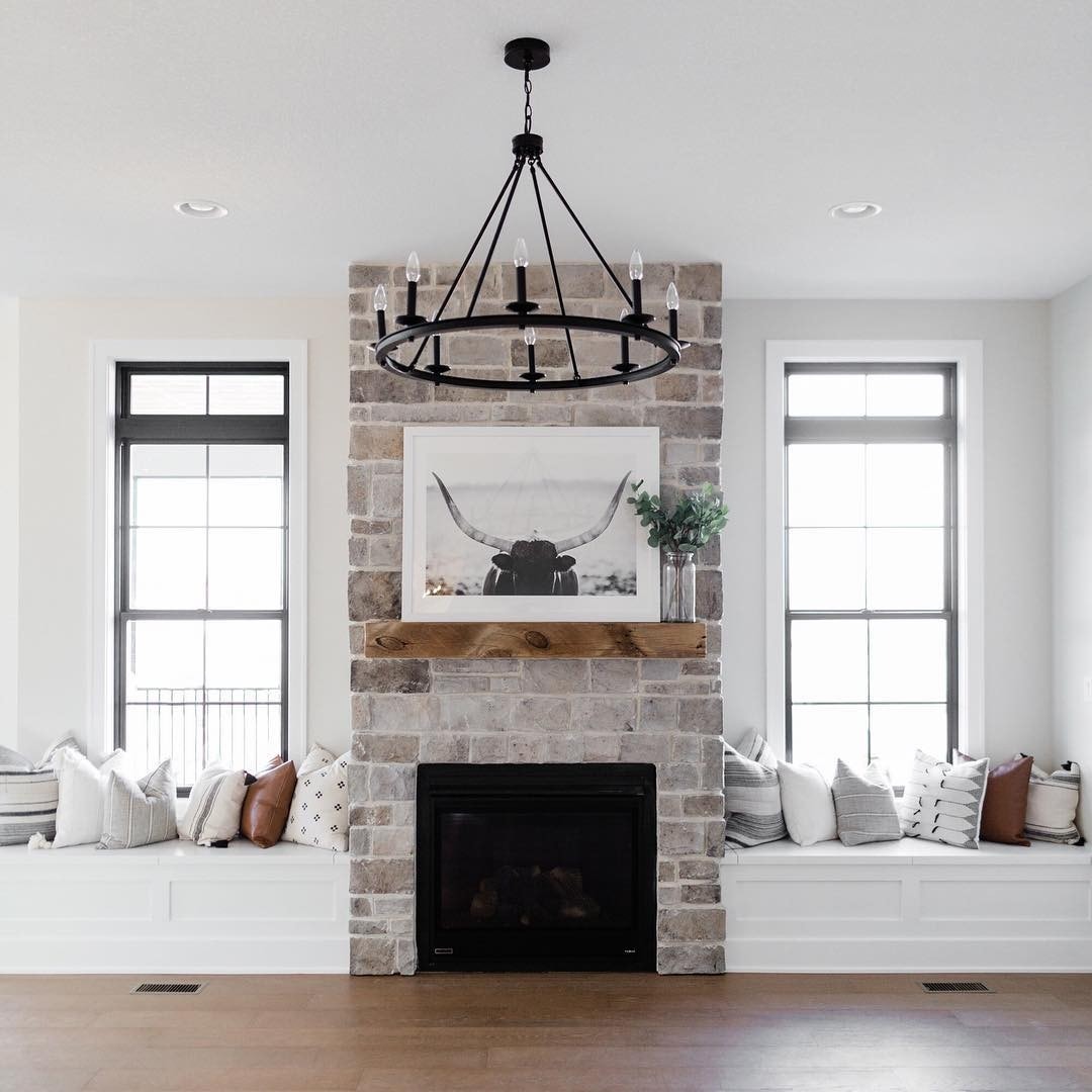 farmhouse style living room with fireplace and black windows