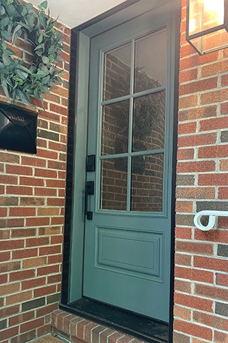 a new blue front door with 3/4 light glass on a brick home