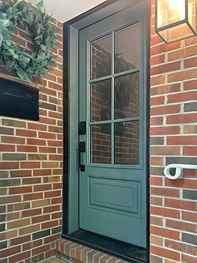 a new blue front door with 3/4 light glass on a brick home