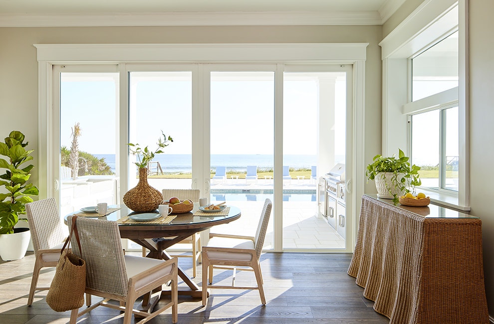 An almond-colored dining room features a sliding patio door that opens to an outdoor pool