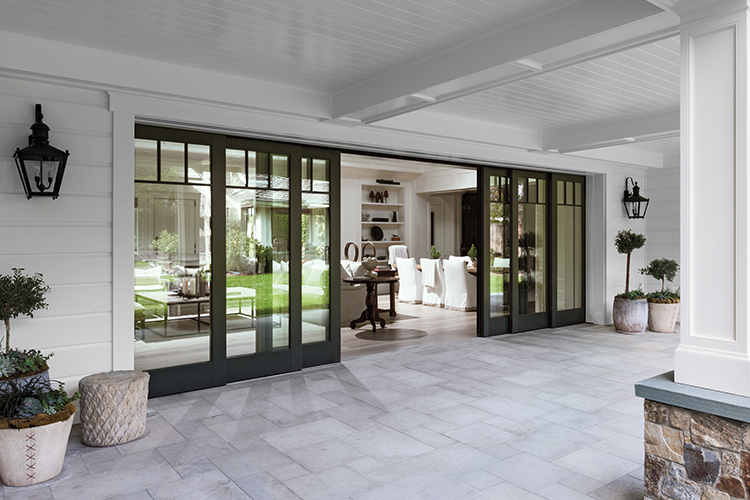 expansive multi-slide patio doors open an interior living room to an exterior patio