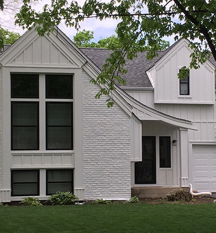 a renovated chicago farmhouse with white-washed bricks and black Pella windows