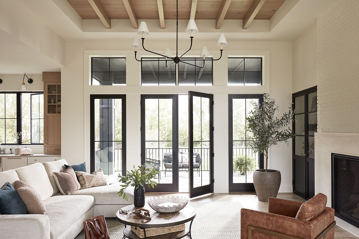 A modern living room featuring black sliding doors, cozy furniture, and a stylish coffee table, showcasing sliding door ideas.