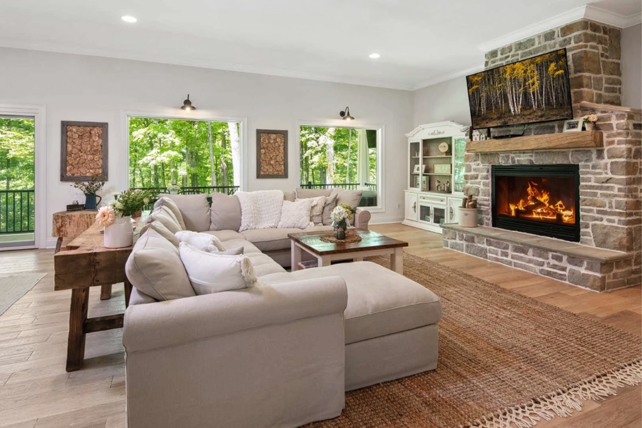 Living room with functional fireplace in newly built Oxford Farmhouse highlighting Pella windows.