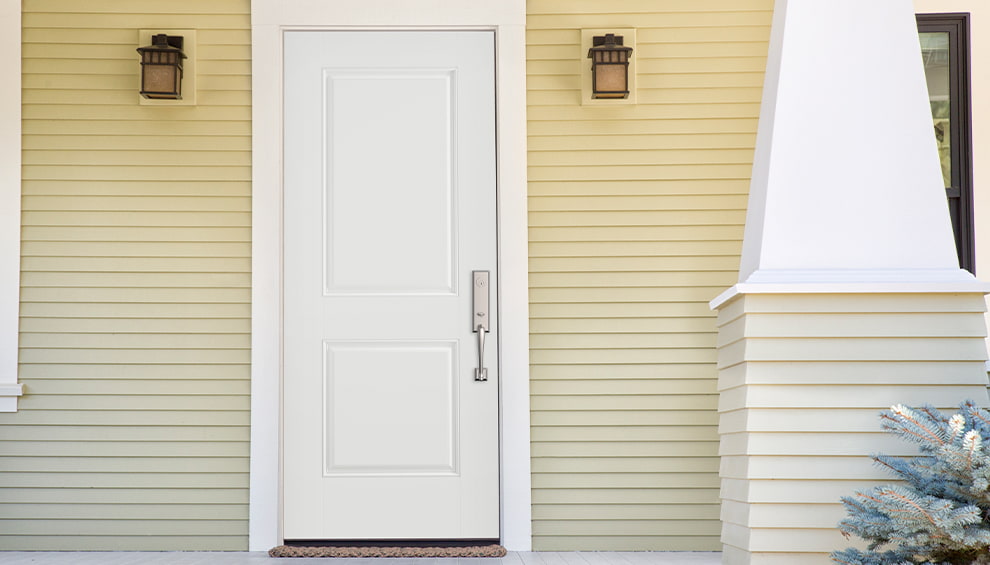 a home exterior with yellow siding and a white front entry door