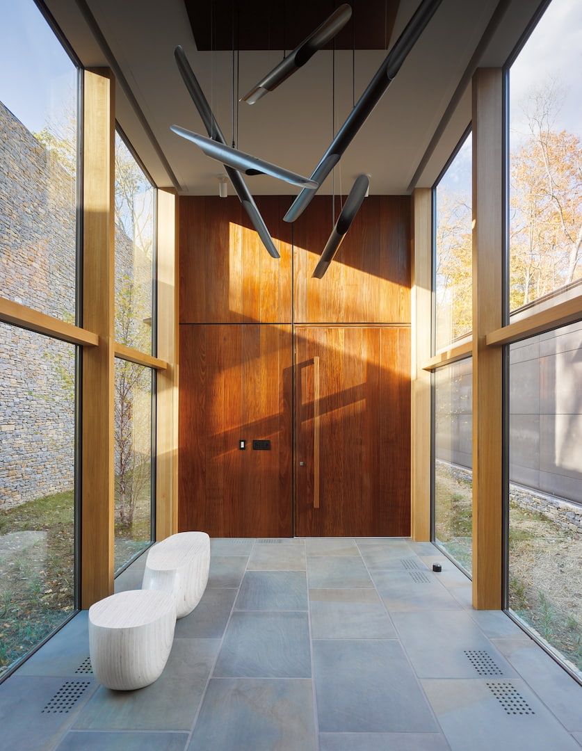 Tall hallway with walls of glass made up of wood picture windows