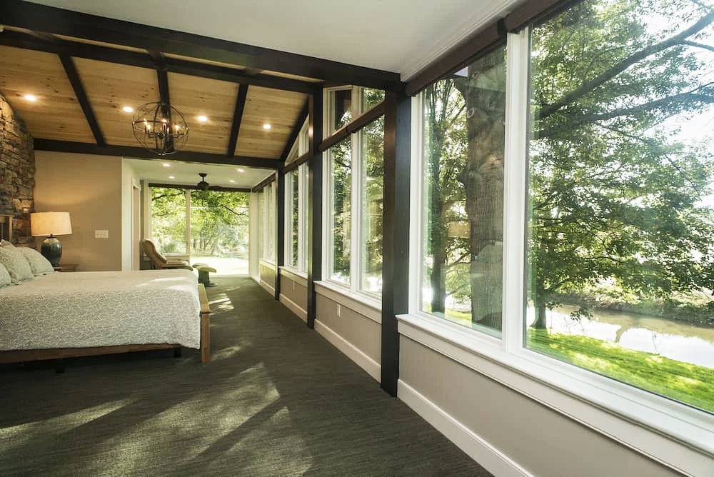 Interior view of Strasburg home bedroom highlighting outdoor view with custom built Pella wood windows.