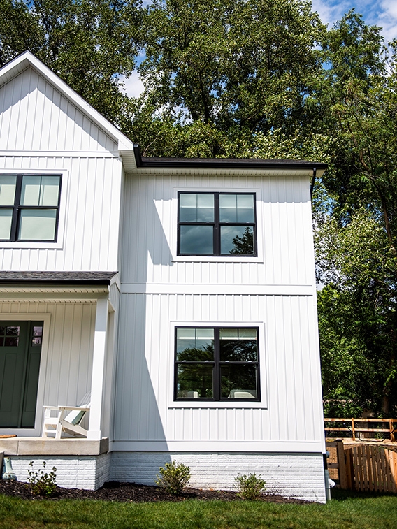 Double-hung windows on front exterior of a white farmhouse.