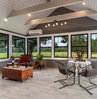 Farmhouse style sunroom with a row of black double-hung windows with white trim