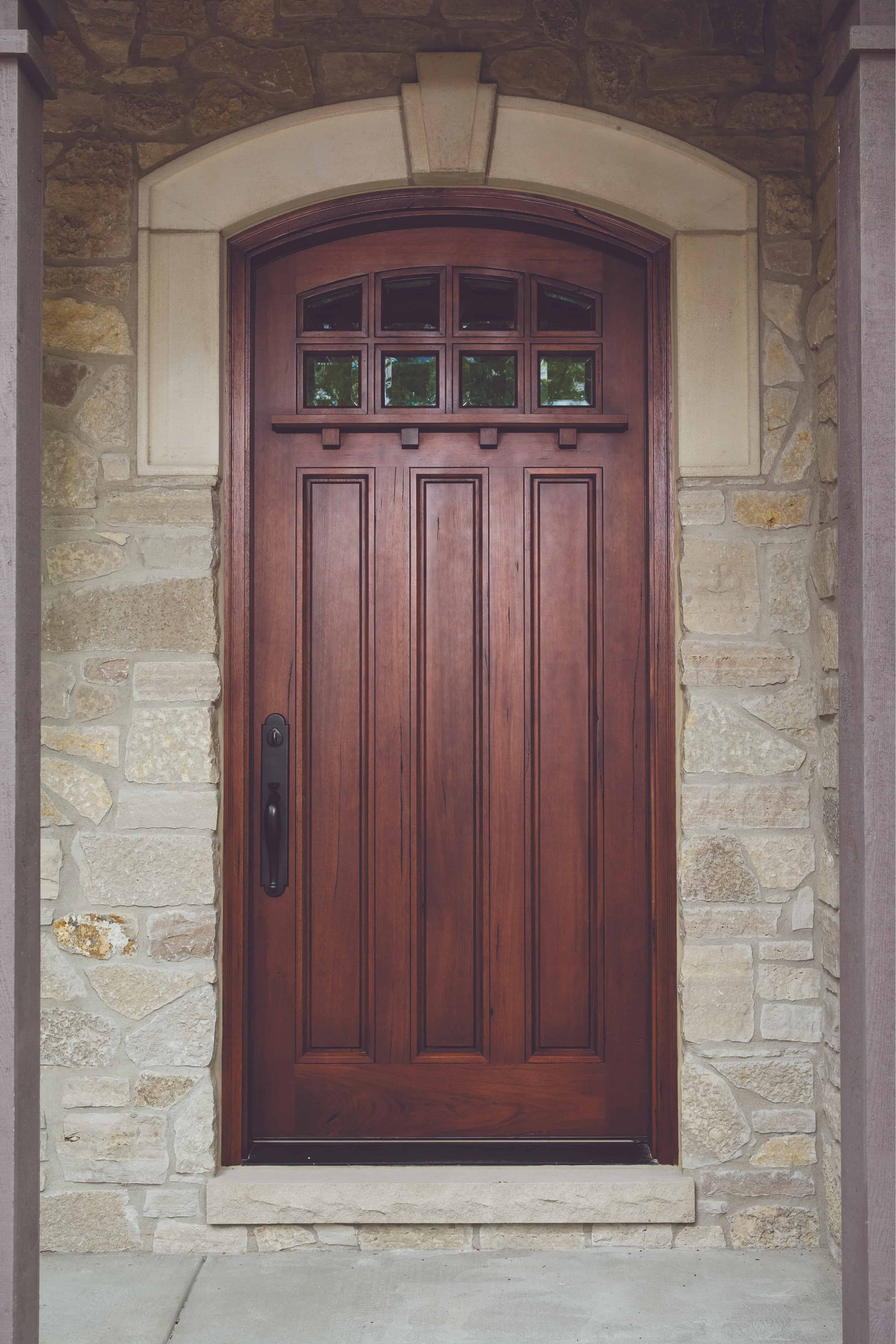 Craftsman style mahogany wood door set in stone entryway