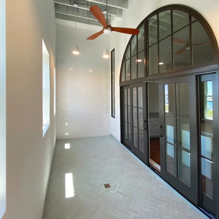 Outside view of newly installed Pella arched windows and sliding patio doors. on Cape Charles Home. 