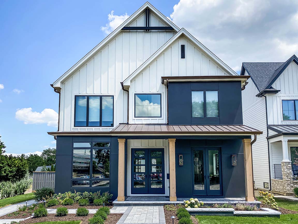 Modern farmhouse front elevation with black-framed windows, board-and-batten siding, and wood porch columns.