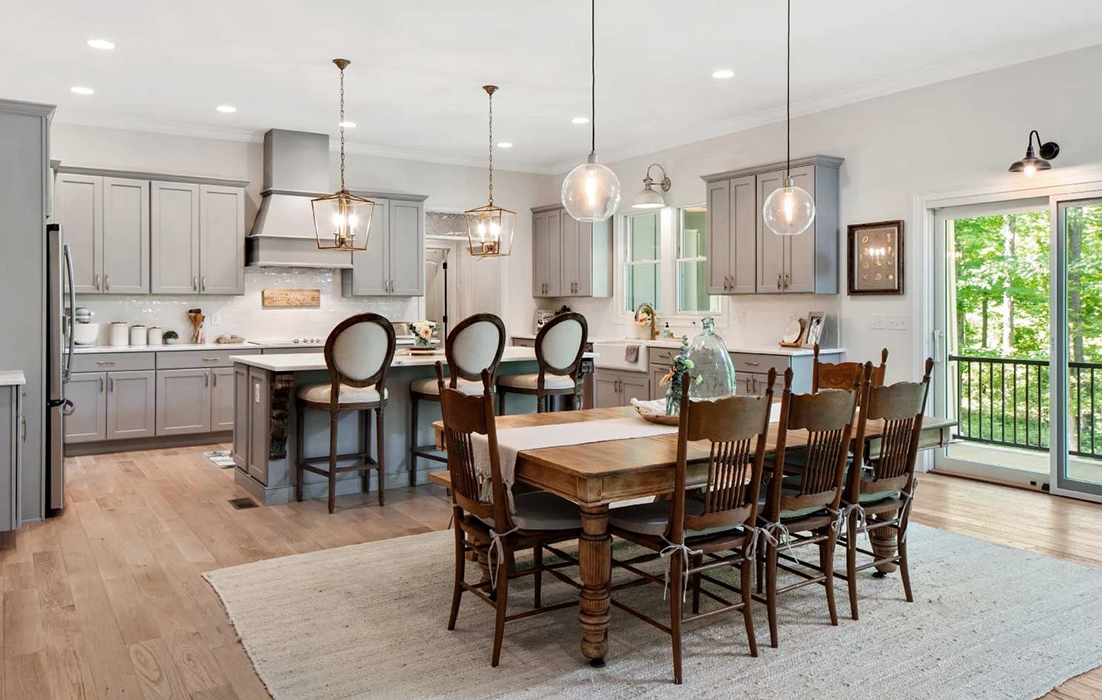 Interior image of Oxford Farmhouse open dining room kitchen area with newly installed Pella sliding glass door.