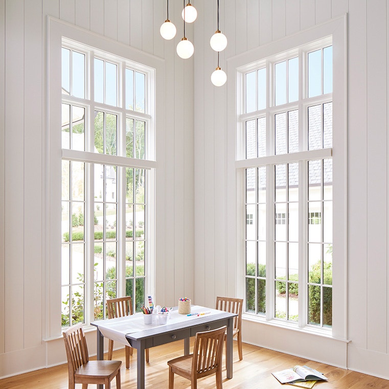 A bright dining room featuring large windows, showcasing natural light.
