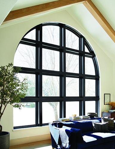 Black frame modern arched wooden windows in Idaho living room.