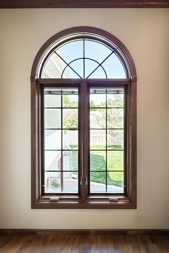 Interior view of arched wood window with divided light grids.