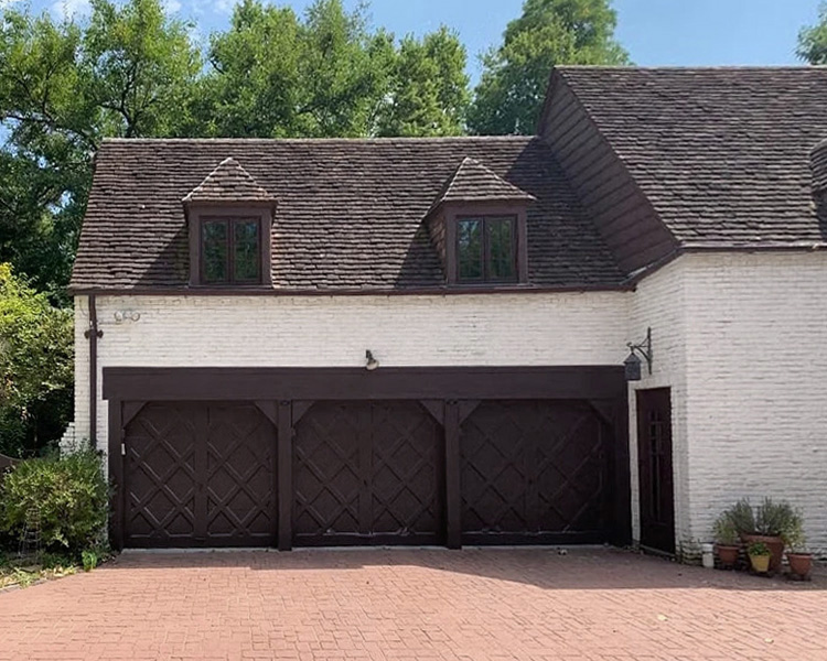 A white historical home in Des Moines with brown windows.