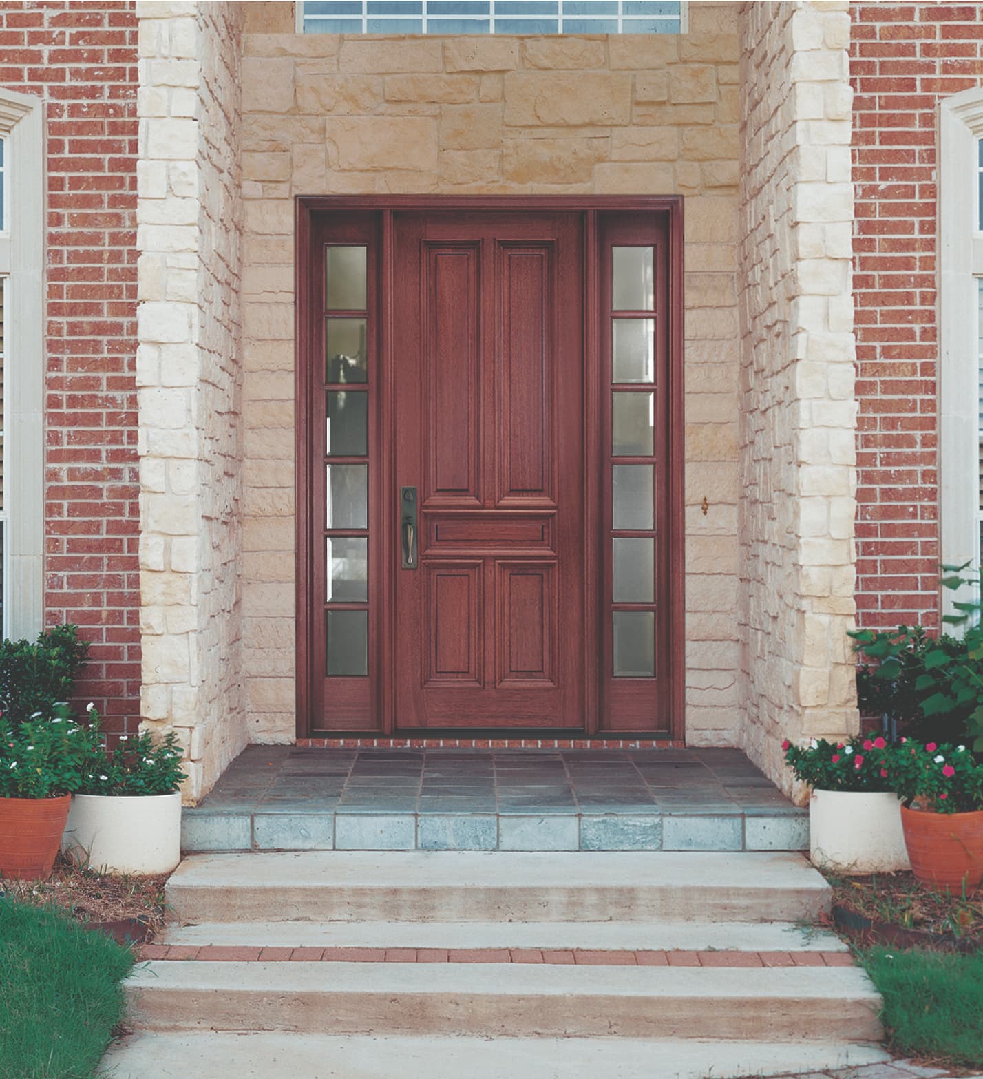 Solid wood door with glass sidelights surrounded by stone entryway