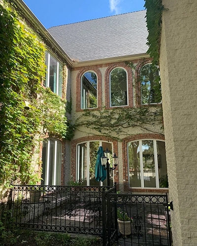 Image of the Norman Education building courtyard with new low maintenance arched vinyl windows.