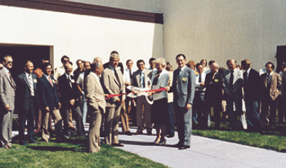 Pella opens a new facility in Carroll, Iowa and the leadership is cutting a ceremonious red ribbon.