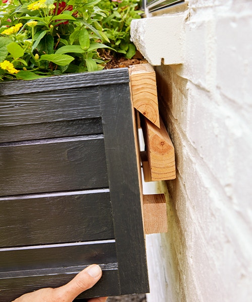 Hanging a window box onto the cleat board that's been attached to the home exterior