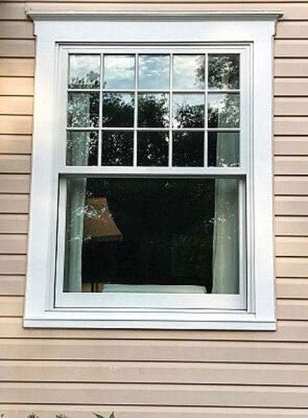 Restored historic wood replacement window with white grilles
