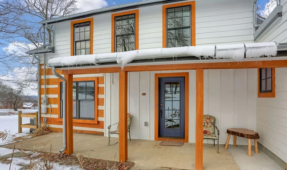 Backyard view of Carlisle farm cabin with newly installed Pella windows and fiberglass door.