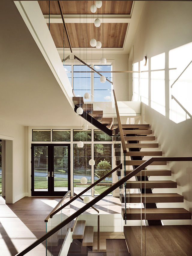 Expansive Pella black windows open up staircase design in Vienna home. 