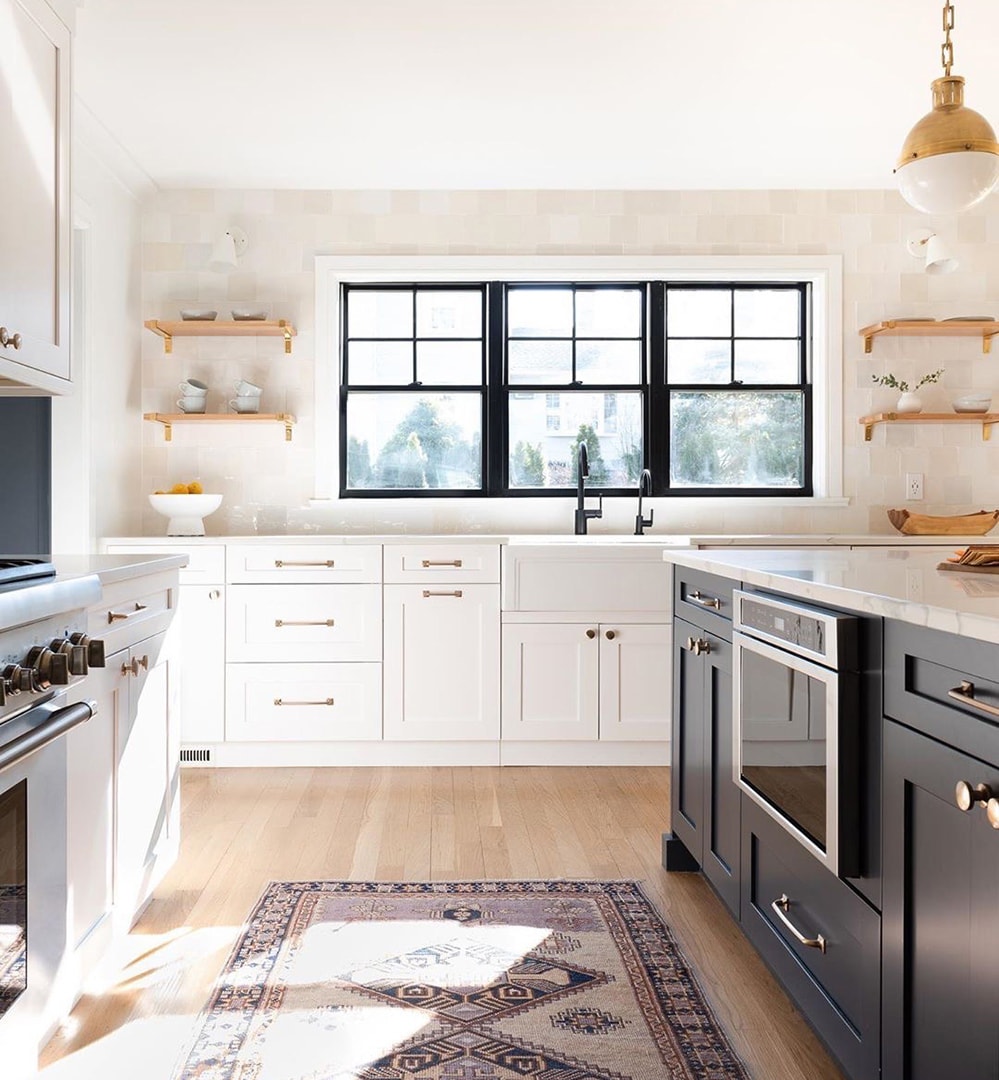 In a bright and spacious kitchen, three black single-hung windows sit side-by-side over the sink.