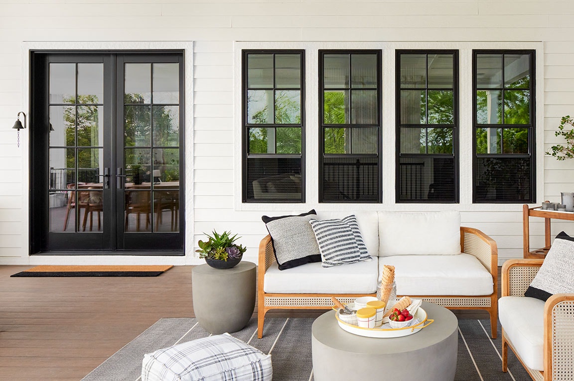 Modern farmhouse with black sliding patio doors, pool area, and a stone path