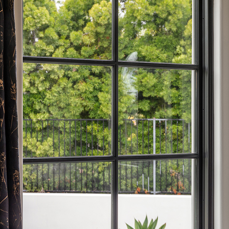 Encinitas home with ILT grilles on arched windows.