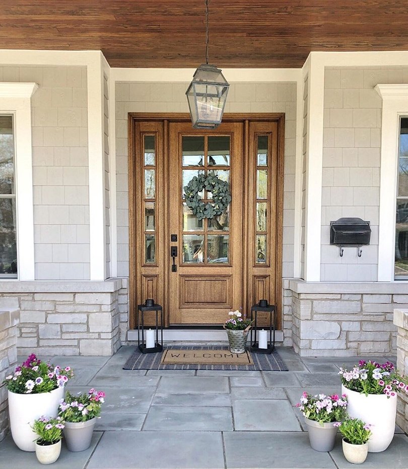 Entryway with a farmhouse style natural wood front door with sidelights on either side